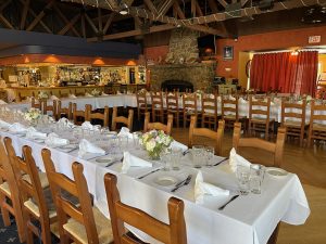 A large dining area with multiple long tables covered in white tablecloths