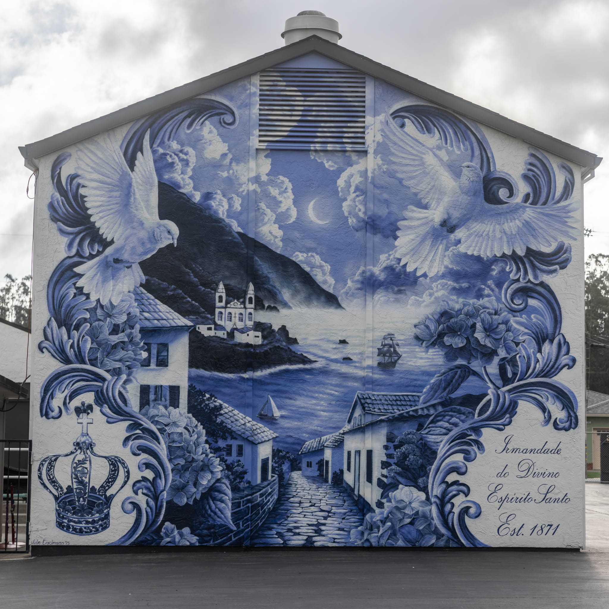 Blue mural on a building showing doves, flowers, a coastal village, and the text “Irmandade do Divino EspĂrito Santo Est. 1871”