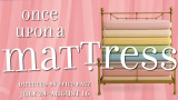 A stack of colorful mattresses piled on a brass bed frame against a pink striped background. Text reads "once upon a mattress," with "mattress" creatively styled with a tilted "T" and an upside-down "r." Additional text at the bottom says "Directed by Erica Racz" and "July 24 - August 16.